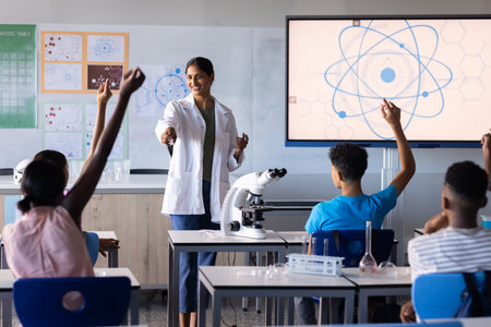 In school, Indian female teacher engaging students in science lesson with microscope and screen. Education, teaching, classroom, technology, learning, STEMの写真素材