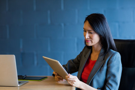 Young businesswoman using digital tablet with colleagues in creative office