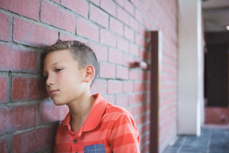 Close-up of a sad boy in corridor at school