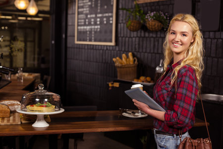 Smiling barista taking credit card from customer at the coffee shopの写真素材