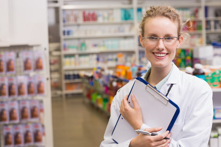 Pharmacist holding clipboard at pharmacyの写真素材