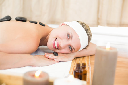 Beautiful blonde enjoying a hot stone massage at the health spaの写真素材