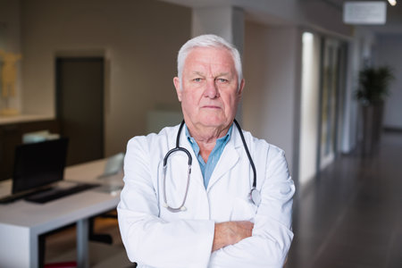Portrait of doctors standing with arms crossed in hospital corridorの写真素材