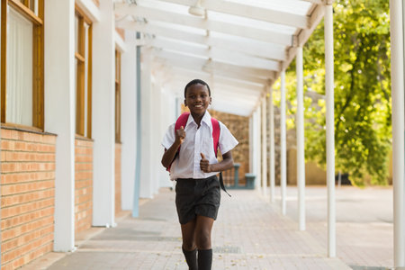Smiling school kids running in corridor at schoolの写真素材
