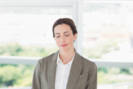 A woman relaxing with her eyes closed in an office.の写真素材
