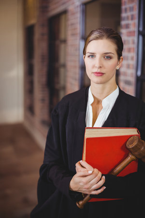Portrait of female lawyer with male colleague standing in background