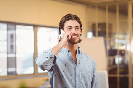 Smartphone leaning on whiteboard near glass partition while sunlight streaming via office windows. Corporate, professional, workspace, modern, communication, freelance, casualの写真素材