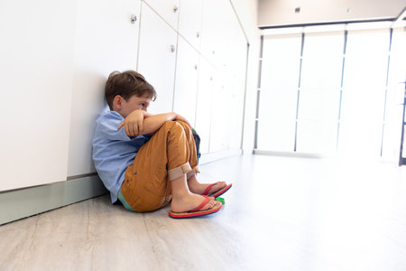 white lockers lining corridor on wood floor, with red flip-flops resting near glass door entrance. Youth, education, corridor, natural light, minimalism, childhood, school environmentの写真素材