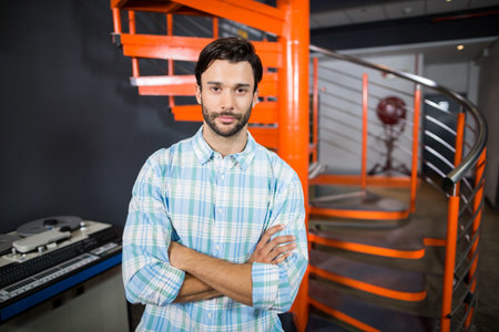 Professional audio mixing console glowing beside orange spiral stairs and industrial fan in studio. Studio, equipment, industrial, modern, engineer, acoustics, creativeの写真素材
