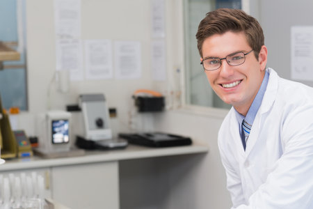 Male scientist wearing lab coat leaning in lab analyzing samples using test tube rack, copy space. Research, innovation, experimentation, precision, technology, science, diagnosticsの写真素材