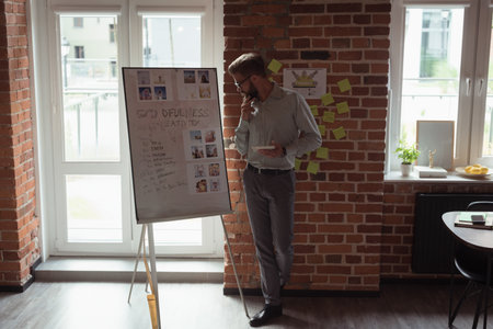 Flipchart leaning on easel in loft office beside window sill with potted plant and lemons....