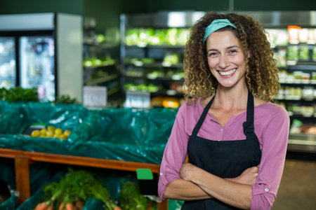 female employee arranging carrots on wooden tables with green liners in produce area, copy space. Fresh vegetables, retail, natural, organization, farm-to-table, health, marketingの写真素材