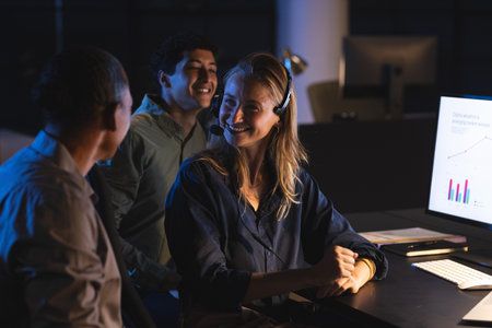 Team collaborating at office, smiling and discussing data on computer screen. Teamwork, collaboration, business, professional, technology, brainstormingの写真素材