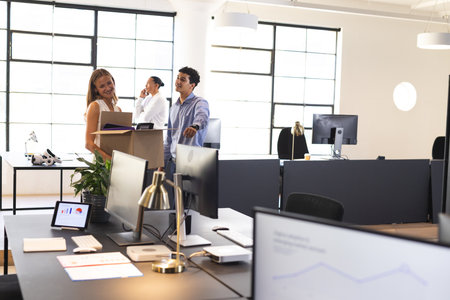 Colleagues discussing project in modern office, smiling and collaborating together. Business, teamwork, strategy, meeting, brainstorming, corporateの写真素材