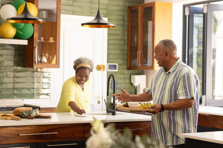 African American senior couple enjoying breakfast together in modern kitchen. Mature, togetherness, lifestyle, elderly, domestic life, bondingの写真素材