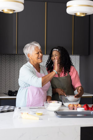 Baking together, grandmother and child in modern kitchen, sharing joyful moment. Family, togetherness, generational, cooking, love, bondingの写真素材