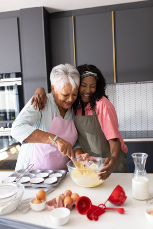 Grandmother and granddaughter baking together in kitchen, sharing joyful moment. Family, bonding, togetherness, multigenerational, happiness, cookingの写真素材