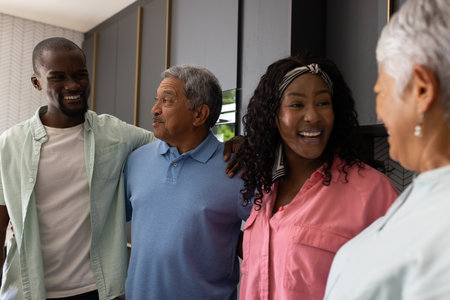 Three generations of family smiling and talking together in modern kitchen. bonding, communication,...