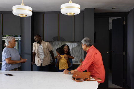 African American family enjoying time together in modern kitchen, sharing laughter. Diversity,...