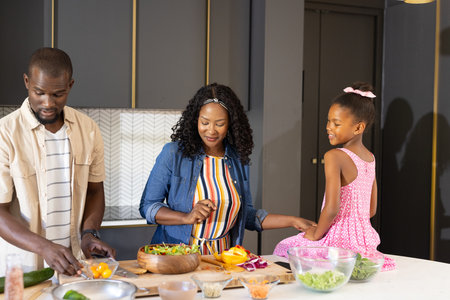 African American family preparing healthy meal together in modern kitchen, smiling. togetherness,...