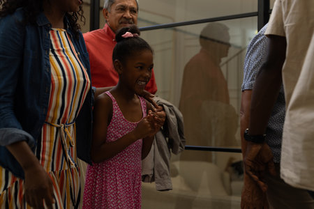 Smiling girl in pink dress enjoying time with family at home. happiness, lifestyle, togetherness, bond, joyful, domesticの写真素材
