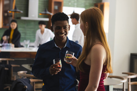 Teenagers enjoying drinks and conversation at lively house party gathering. Socializing, celebration, friendship, youth, beverages, nightlifeの写真素材