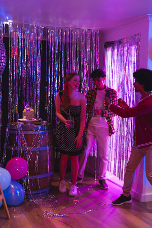 Teens celebrating at home, taking photos and enjoying party decorations. celebration, teenagers,...