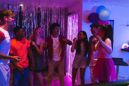 Teenagers dancing and laughing at home during vibrant birthday celebration. Party, fun, friends, youth, entertainment, festiveの写真素材