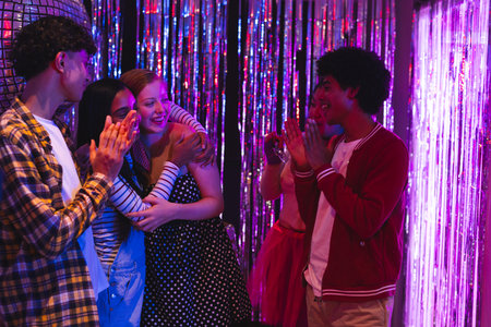 Teenagers celebrating together at party, clapping and smiling with joy. Celebration, gathering, friendship, happiness, excitement, joyfulの写真素材