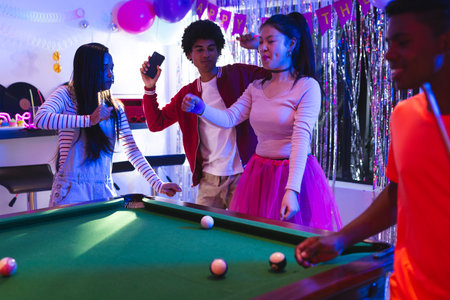 Teenagers celebrating at party, dancing and playing pool with joyful expressions. Celebration,...