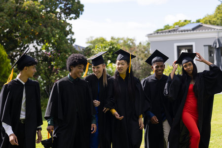 In school, graduating students wearing caps and gowns celebrating joyfully outdoors. Graduation, ceremony, achievement, celebration, commencement, academicの写真素材
