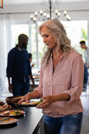 Woman serving food at reception, smiling and enjoying celebration. catering, hospitality, event, festive, joyful, happinessの写真素材