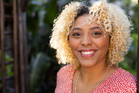 Smiling woman enjoying sunny day outdoors in casual attire. fashion, lifestyle, happiness, leisure, summer, positivityの写真素材