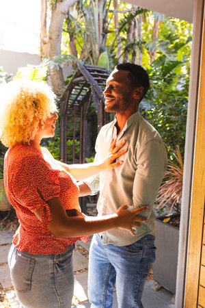 Friends enjoying warm conversation in sunny garden, sharing joyful smiles. Friendship, outdoors,...