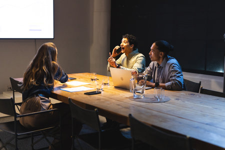 Discussing strategy, business professionals using laptop and smartphone in meeting room. Teamwork,...
