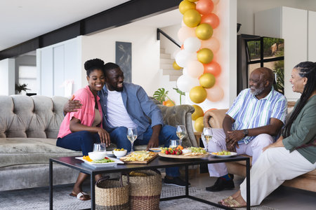 Family enjoying joyful celebration with snacks and drinks in cozy living room. togetherness,...