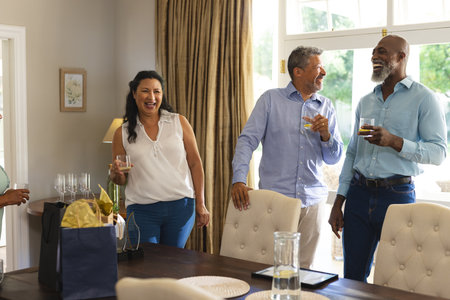 Seniors enjoying drinks and laughter at home during joyful celebration. Elderly, happiness,...