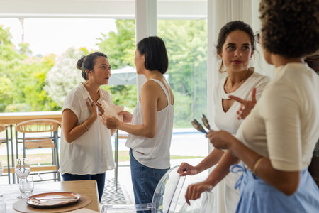 Women in casual attire chatting and preparing for wedding celebration at home.の写真素材