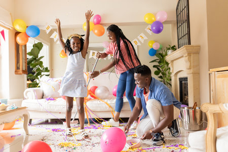 Decorating with balloons and confetti, family celebrating birthday joyfully at home. Celebration, party, decoration, happiness, colorful, festiveの写真素材