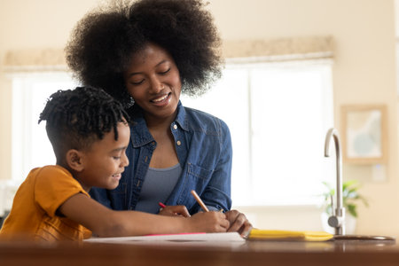 Mother and child drawing together at kitchen table, enjoying creative time. Family, bonding, creativity, art, parenting, childhoodの写真素材