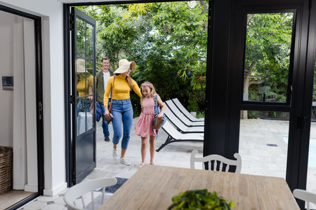 Family entering home from patio, smiling and enjoying sunny day together. happiness, sunshine, lifestyle, outdoors, bonding, togethernessの写真素材