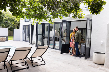 Happy family stepping outside to enjoy sunny day by poolside patio. outdoor, leisure, summer, relaxation, recreation, togethernessの写真素材