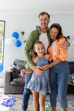Happy family celebrating at home with balloons, smiling and embracing together. celebration, togetherness, joy, bonding, happiness, indoorsの写真素材