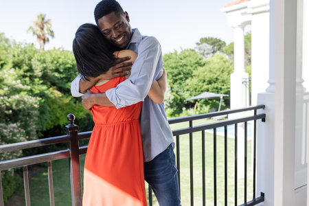 Couple embracing on balcony, enjoying sunny day at outdoor wedding venue. Romance, celebration, love, togetherness, outdoors, ceremonyの写真素材