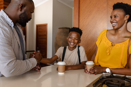 Senior couple placing and lighting candles on chocolate-drip cake for birthday party on grey sofaの写真素材