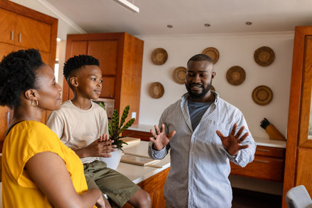 Family enjoying quality time together in cozy kitchen, sharing stories and laughter. bonding, togetherness, home, happiness, storytelling, relationshipの写真素材