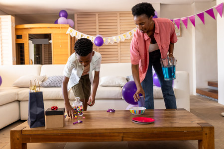 Mother and son decorating living room for birthday party with colorful balloons. Celebration, family, festive, decorations, cheerful, happinessの写真素材