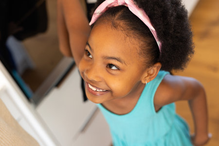 Senior couple wearing party hats toasting flute glasses at home celebrating birthday cake huggingの写真素材