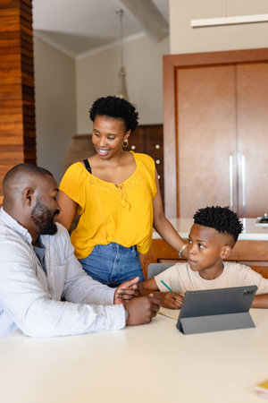 Family enjoying quality time at home, parents engaging with son using tablet. technology, bonding, parenting, digital, leisure, interactionの写真素材