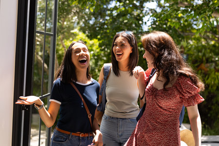 Laughing together, three young women enjoy sunny day outdoors. Their friendship radiates happiness...